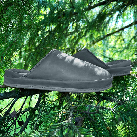 SPA GAIT Storm Ash brown leather clogs photographed outdoors against fir tree foliage. Eco friendly clogs with adaptive footbed and natural leather finish.
