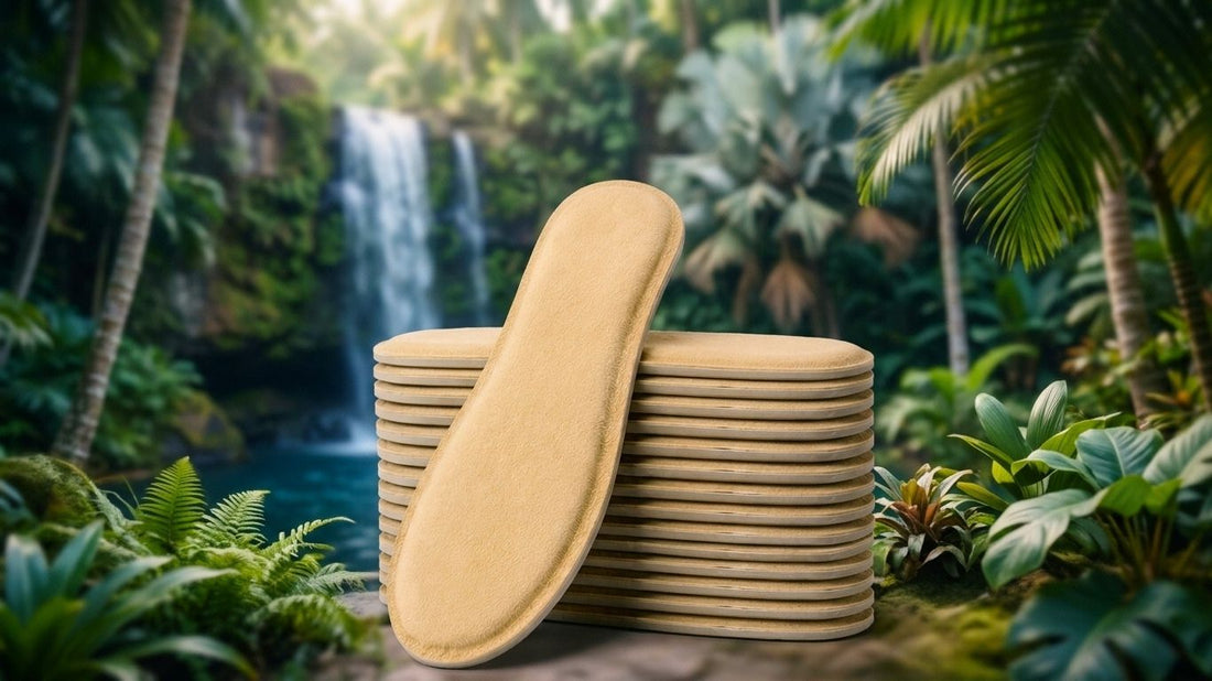 Stack of SPA GAIT adaptive leather insoles in a tropical jungle setting with a waterfall. Natural breathable materials for everyday comfort.