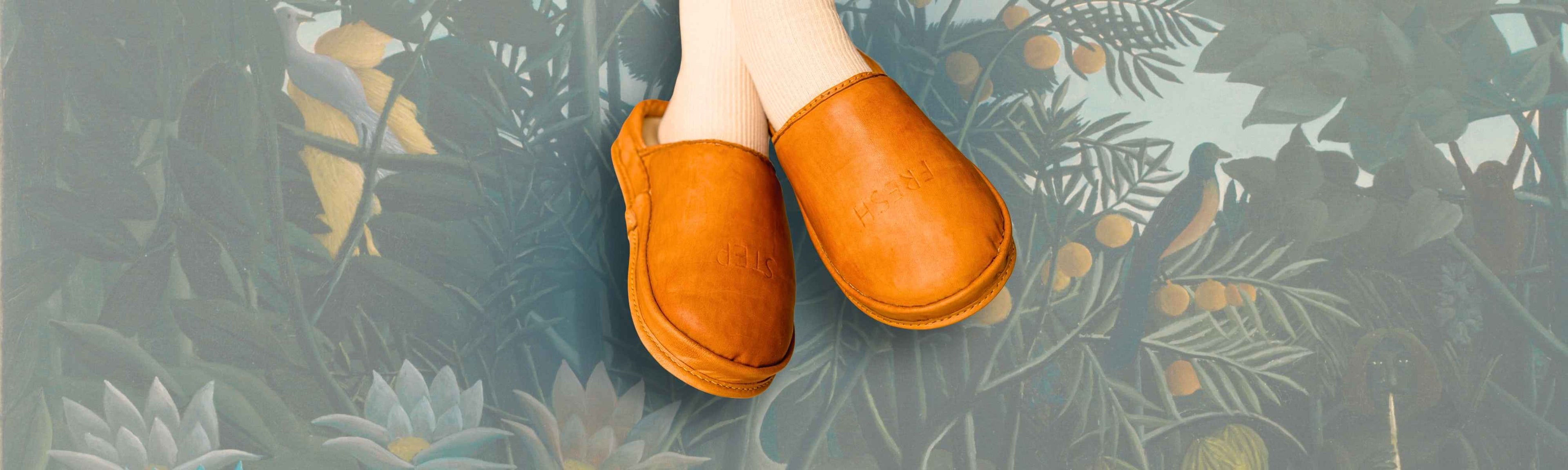 Anatomical shoes by SPA GAIT in a warm brown color, shown on feet against the painting. These natural leather clogs are the ultimate leather comfort clogs.

Brown leather clogs by SPA GAIT on feet, emphasizing the shoe's anatomic fit. The leather slippers are a unique example of art clogs and eco friendly clogs.

SPA GAIT leather clogs for women photographed against a background of jungle art. These soft leather clogs are art clogs designed for clogs comfort and mindful living.

