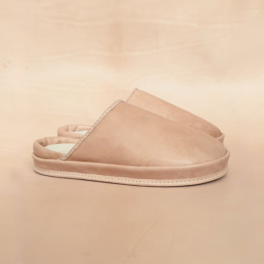 Beige leather slippers on a beige background