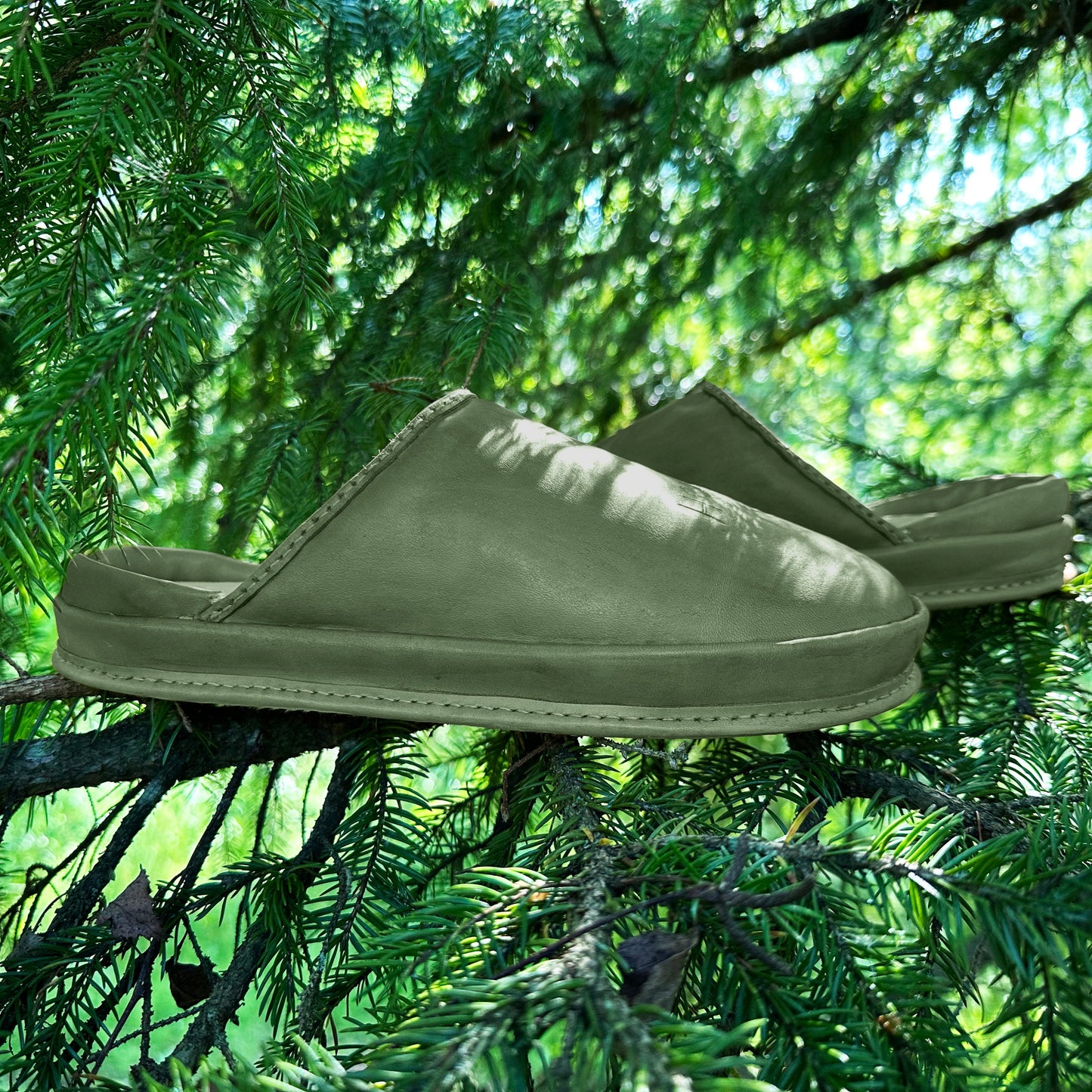 Forest Core leather clogs on greenery. This photo highlights our comfortable leather clogs for women and their natural origin.