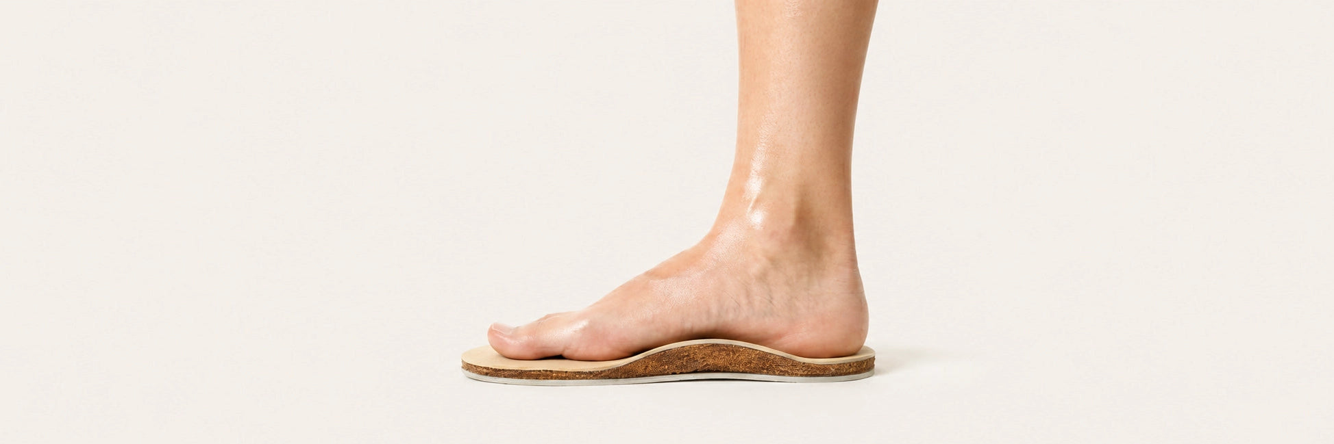 Bare foot standing on SPA GAIT breathable adaptive insole showing three layers: natural leather top, coconut fibre middle and cushioning base. Designed to mould to your feet for personalised support and all-day freshness.