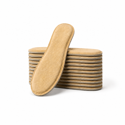 SPA GAIT Solid Adaptive Leather Insoles 10 Pairs stacked with one insole leaning against the pile, showing the premium genuine leather surface and thicker supportive construction.