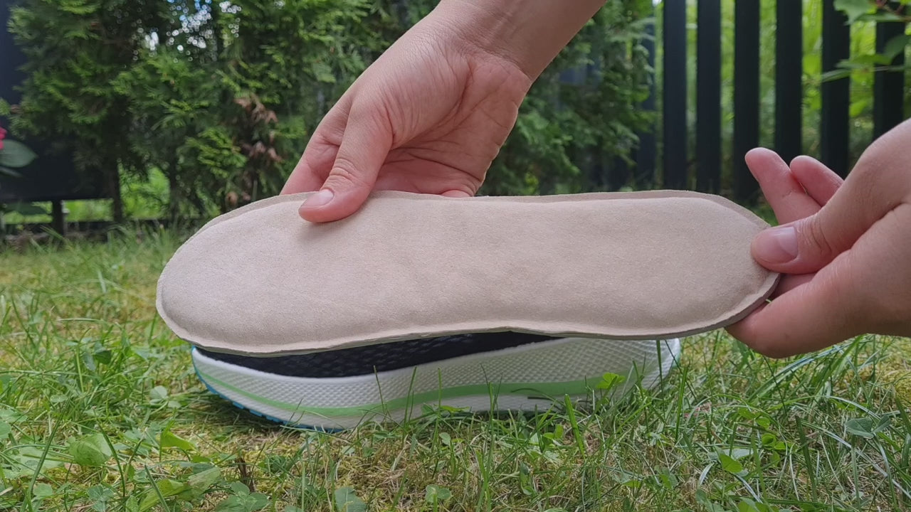 A person outdoors demonstrates the flexibility and smooth texture of the beige SPA GAIT Basic Leather insole. The video includes a quick step-by-step guide on inserting the insole into a black shoe, ending with a banner showing how it moulds to the foot after 10 hours of wear.